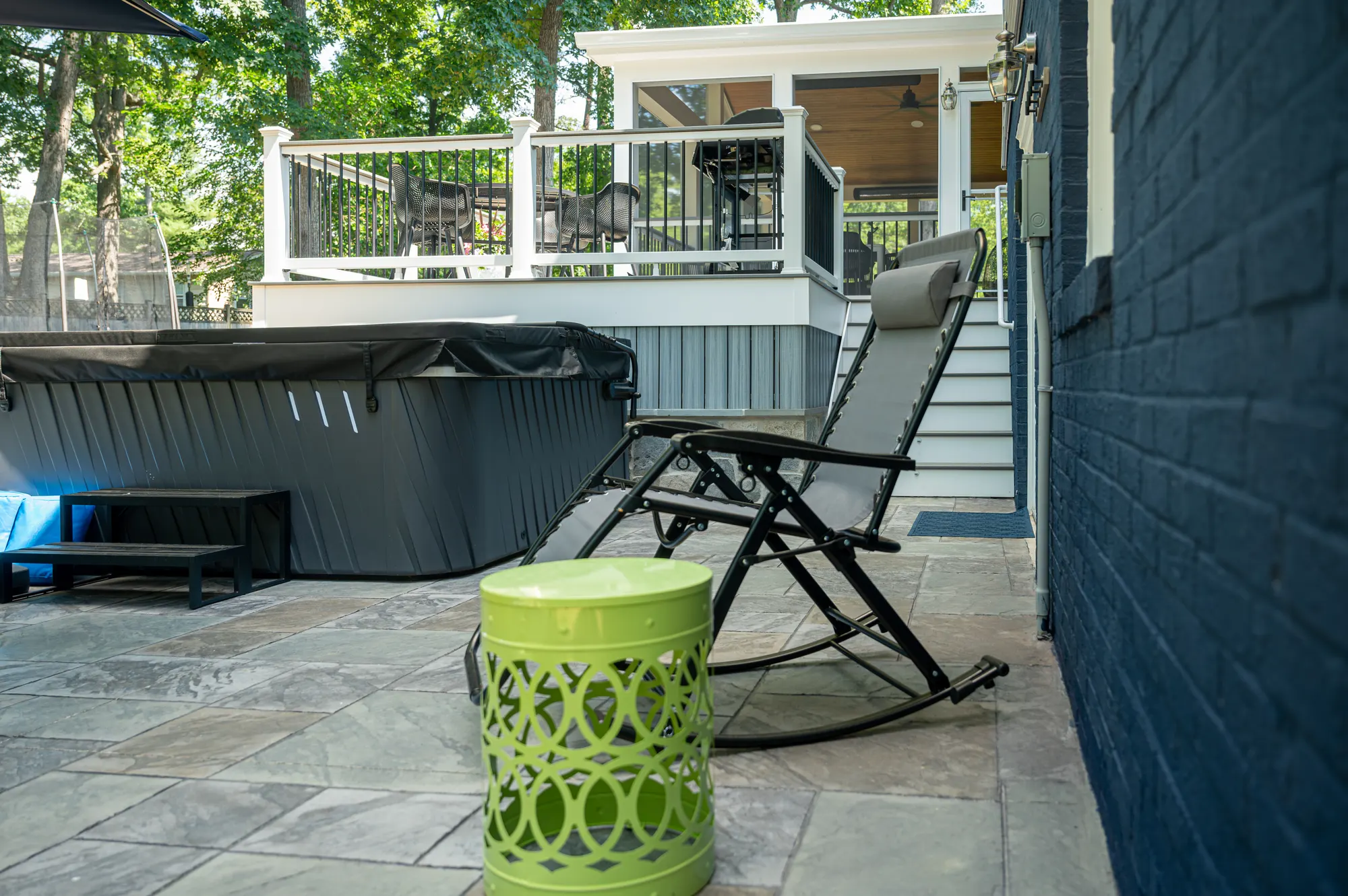 Flagstone patio with hot tub below a two-level deck
