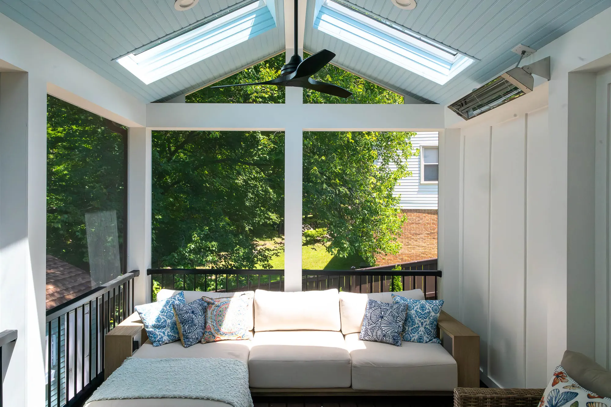 Vaulted porch with skylights, ceiling fan and a white sectional