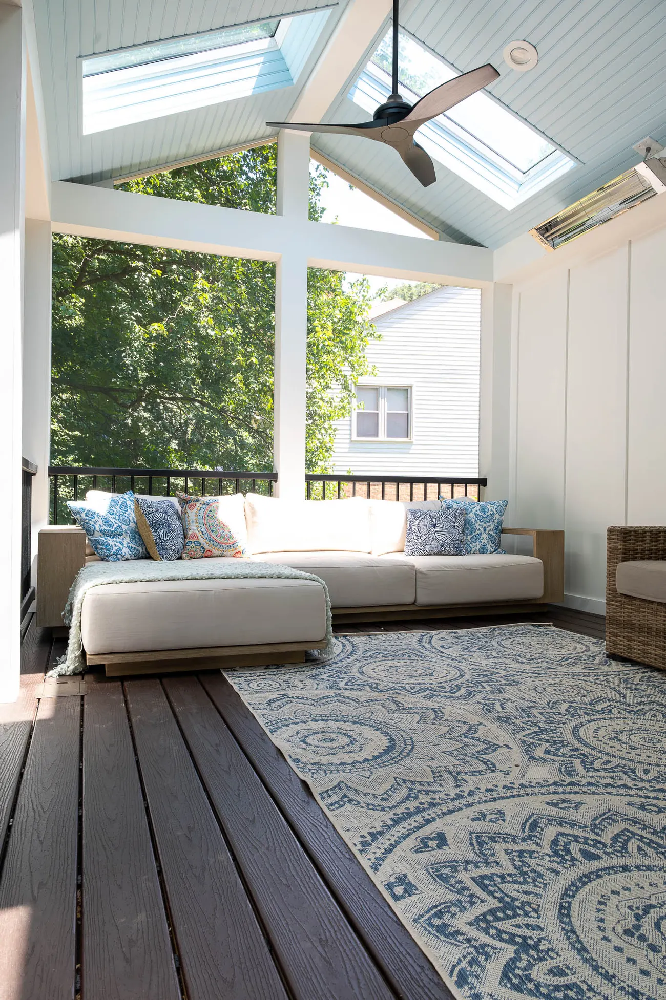 Vaulted screened porch with skylights, white board walls and a lounge sofa