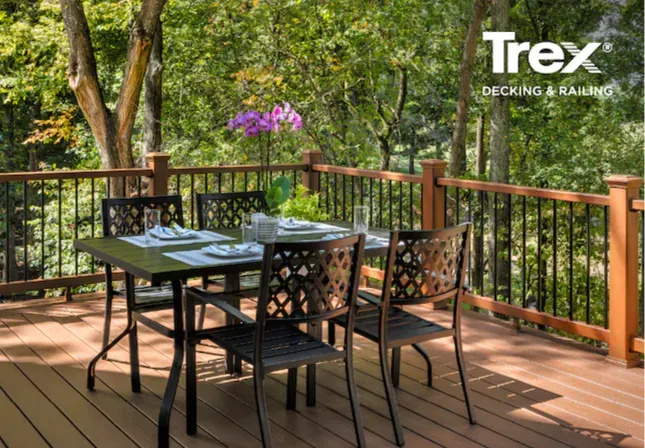 Trex deck with outdoor dining area and black metal railing, sustainable backyard design trends for